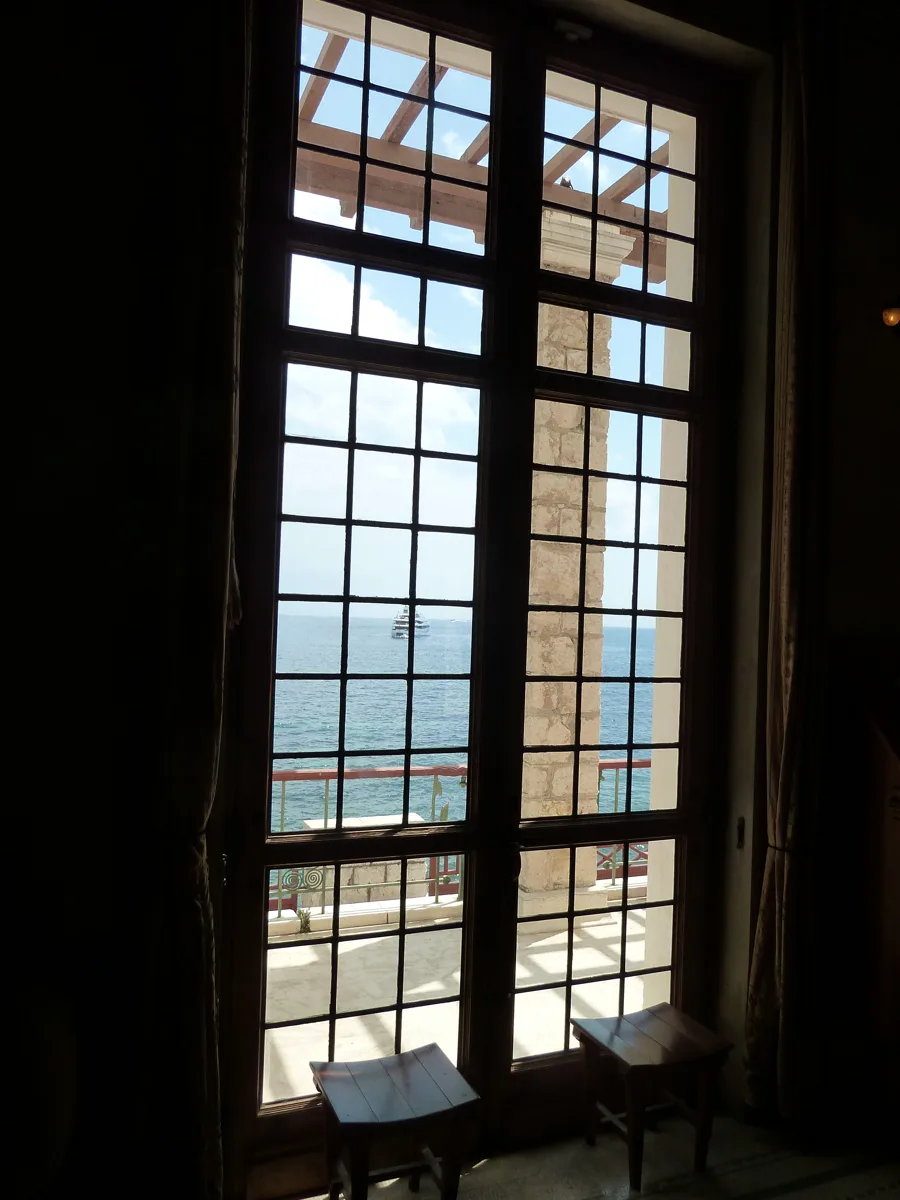 Tall windows of the Villa Kérylos at Beaulieu-sur-Mer opening onto the sea. Architectural reference, not a project of the House.