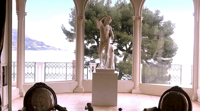 A private arched loggia opening to the sea, classical chairs turned toward the water.