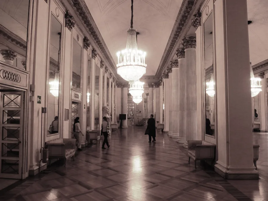 The chandelier-lit foyer of the Teatro alla Scala, Milan. Architectural reference, not a project of the House.