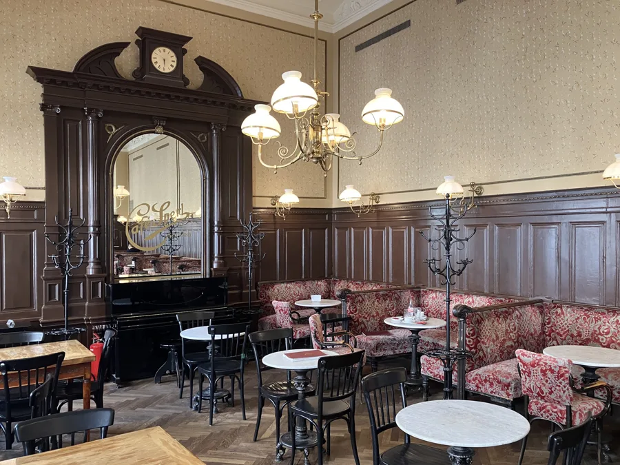 Café Sperl in Vienna, with its panelled walls, chandeliers and marble tables. Architectural reference, not a project of the House.